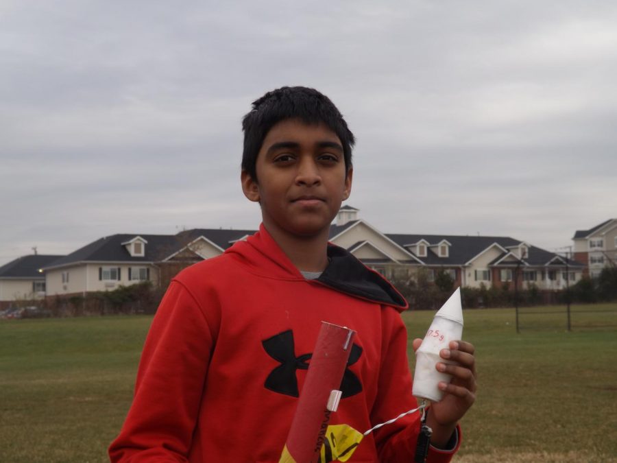 An eight grader with a rocket that has just landed with a glider. 