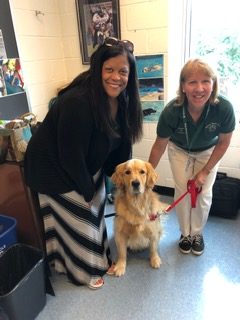 Ms. Terry, assistant principal of RCMS, and Ms. Doyle, Tucker’s owner, pose with Tucker, a therapy dog, on May 30. 