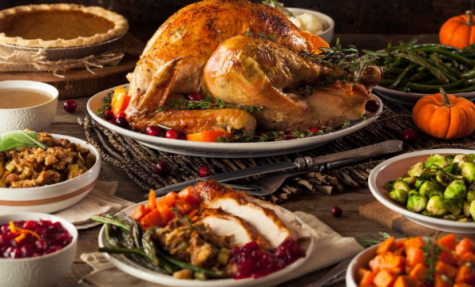 This is an example of a hot traditional and modern Thanksgiving meal. It has a turkey in the middle surrounded by side dishes and desserts but it is modernized by the new cuisine dishes instead of the traditional ones.