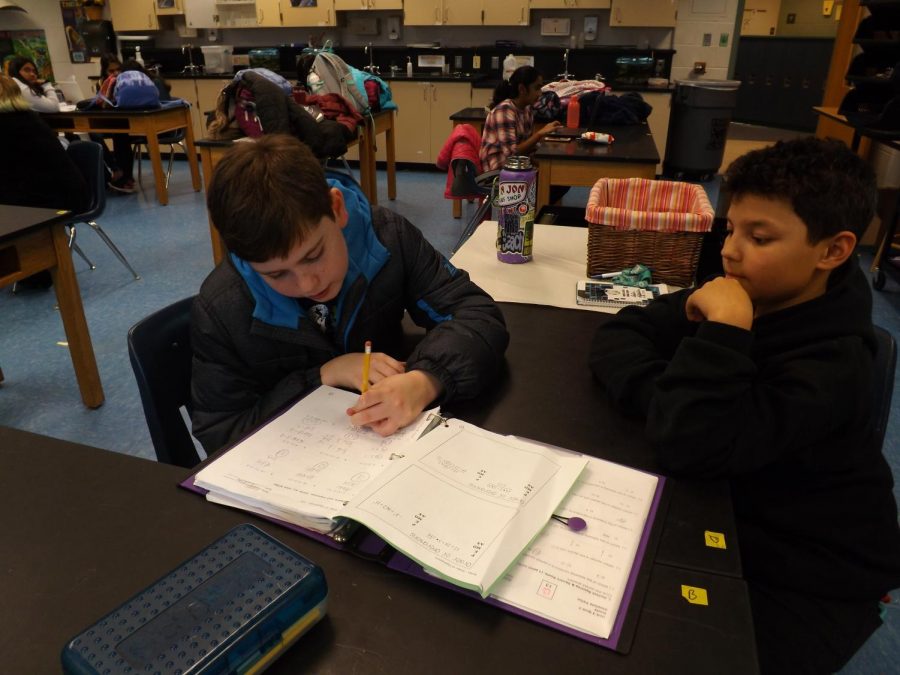 Mason Baldwin, on the left, explains a math problem to Malaki Breenden, on the right, on Dec. 2.

