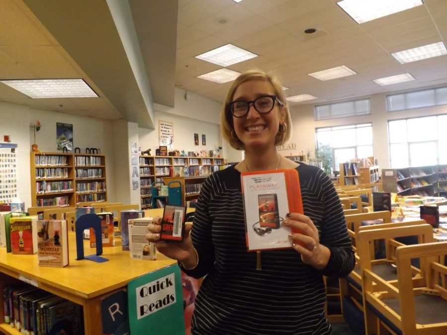 One of Carsons librarians, Ms. Elizabeth Donovan, holds the new library copy of the audiobook of “Grenade, by Alan Gratz.