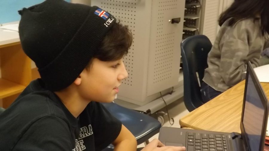 Rehaan works on his articles for the Carson Chronicle with his trademark beanie on his head. Photo by Reema Yaghi.