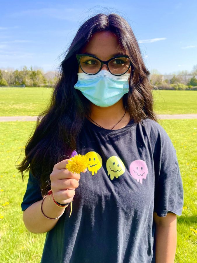 Anshika Bansal, an eighth-grader on the X-Treme team,   holds a bright yellow, perennial weed.