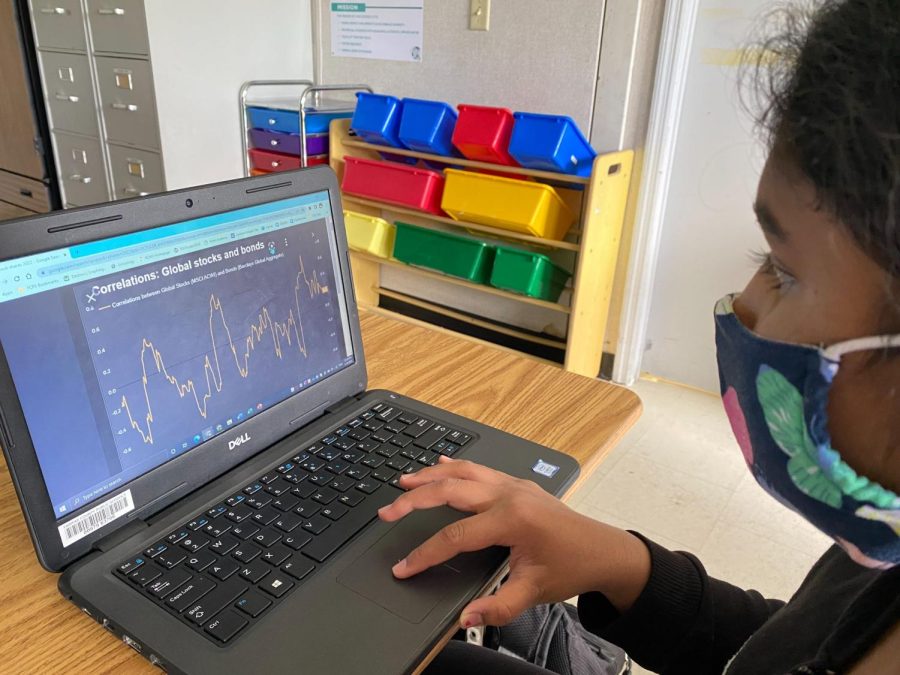 Shloka Yada, a seventh-grader from the Champions team, is analyzing data for stock market shares.
