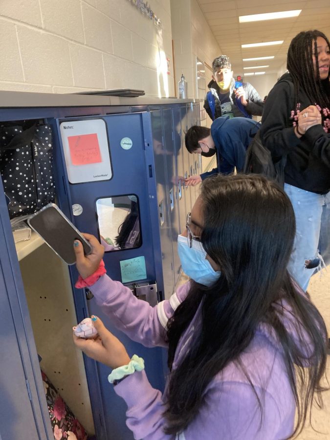 Daanya Saraff, an eighth grade student on the Discovery team, keeps her phone in her locker prior to the beginning of the school day.
