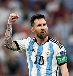 Lionel Messi puts his arm up in pride at the 2022 World Cup.

Photo courtesy of Tasnim News Agency; photo is not altered; https://creativecommons.org/licenses/by/4.0/deed.en