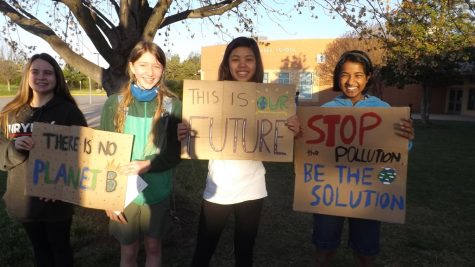 Fridays for Future members hold up signs. From left: Momo Lepsch, Sienna McIntyre, Ariya Lee, Nethra Purushothaman.
