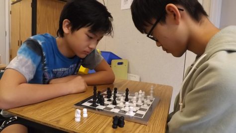 Tyler Shin (left) and Dylan Lu (right), eighth-graders on the Discovery team, play a game of over-the-board chess, a style of playing that many have switched to at RCMS.