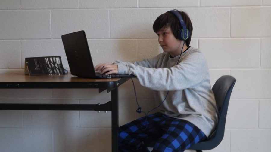 Seventh+grade+Mavericks+student%2C+Charlie+Curtis+working+on+his+computer+while+wearing+pajama+pants.