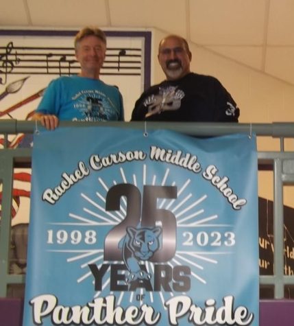Mr. Kirk Treakle, librarian, and Mr. Moosa Shah, retired science teacher, share a smile by the 25th anniversary sign.