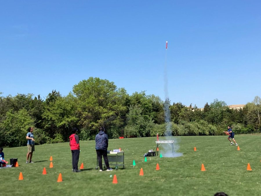 Sixth period engineering 2 students launching their rockets more than 100 feet in the air in the field behind the trailers.