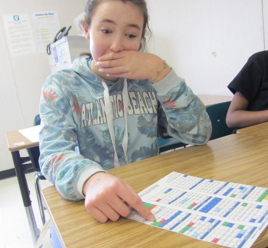Seventh-grader Alara Krause points at the school calendar.