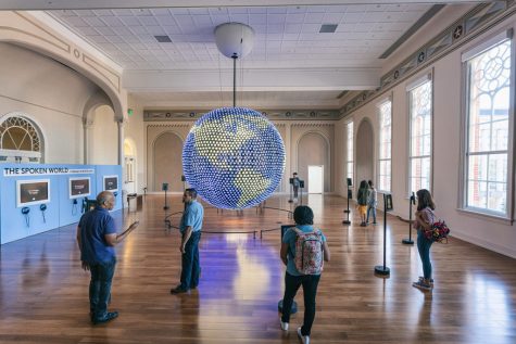 Visitors interact with the language globe exhibit on the third floor of the museum.