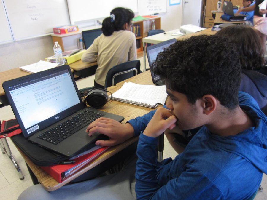 Arnav Nair, seventh-grader intently working on his laptop in class. 