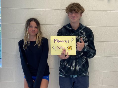 Josephine Leon-Guerrero (Left) and Cannon Berejik (Right) holding up a Memorial day sign