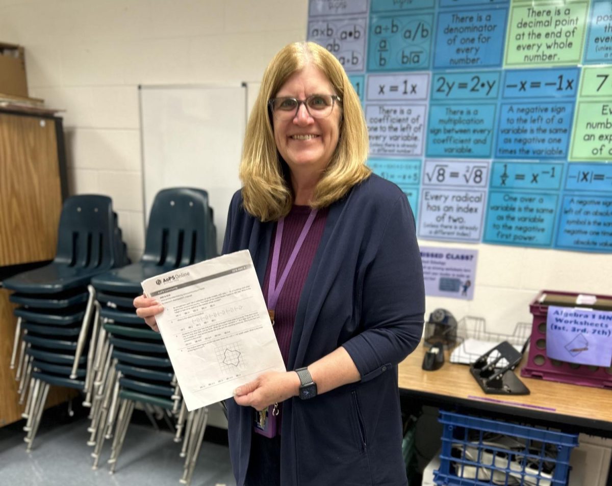 Mrs. Cahill holding up practice papers for AMC 8.