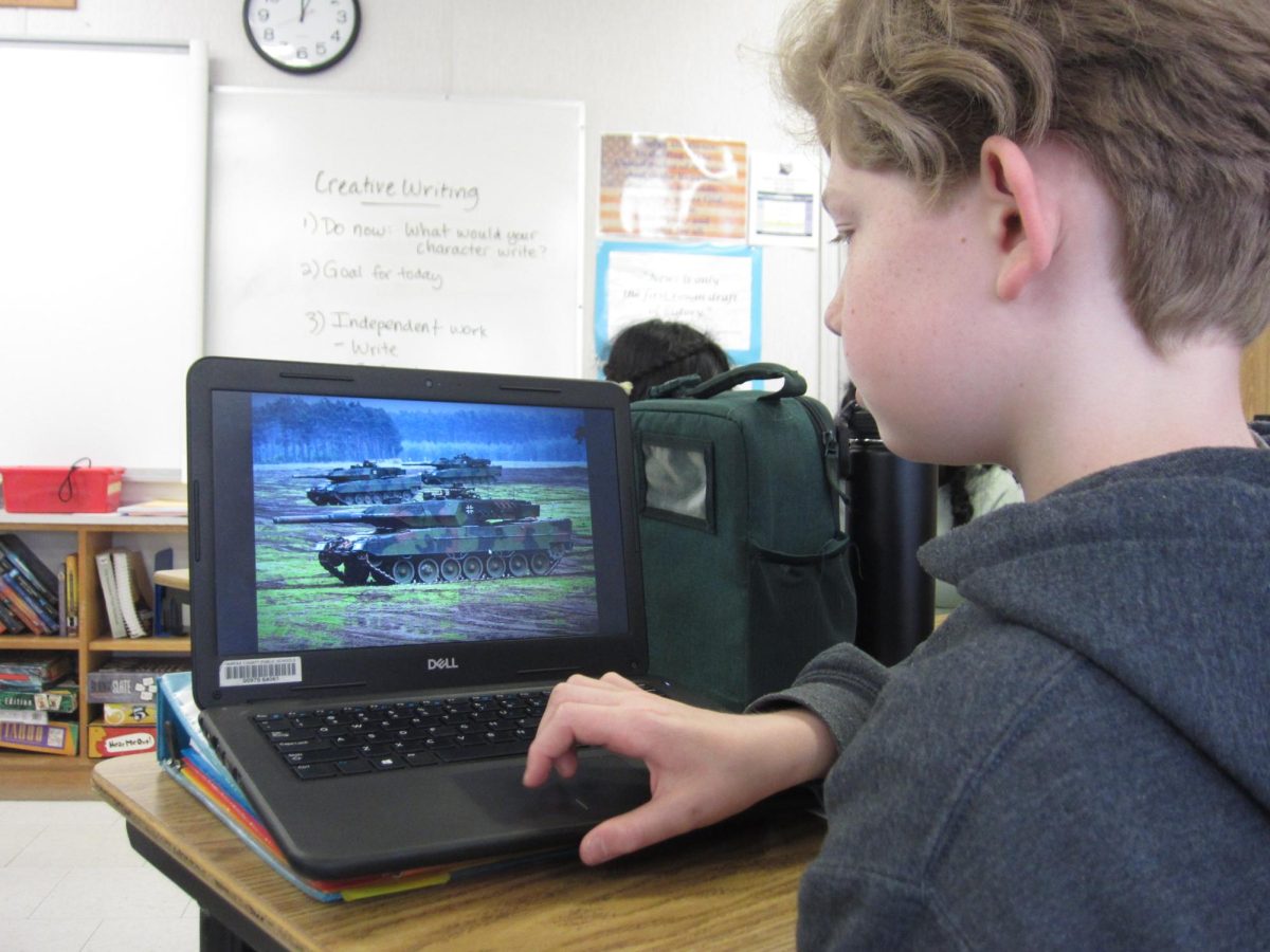 Seventh grader James Steare looking at an image of a modern German tank that was gifted to Ukraine for the fight against Russia.