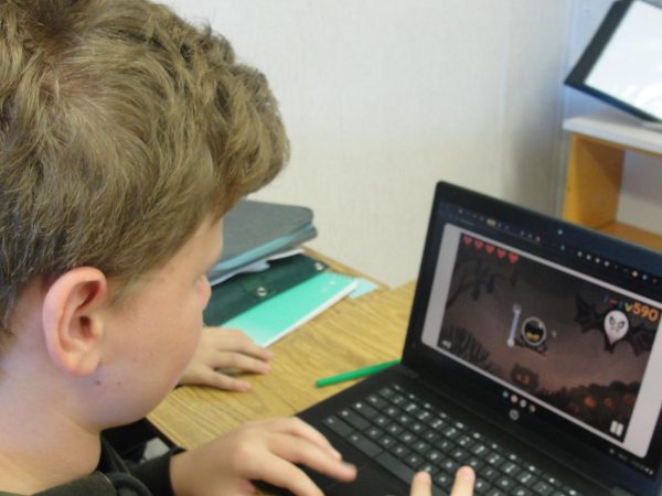 Gage Mastroianni, 13, of the Voyagers team, plays the "Halloween 2024" doodle on his computer.